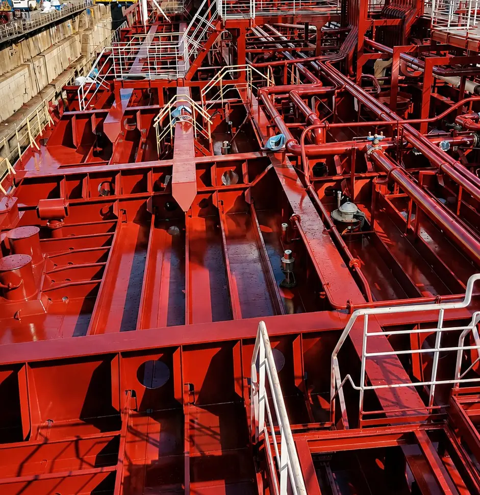 Deck of a tanker with piping and structures coated in red protective paint